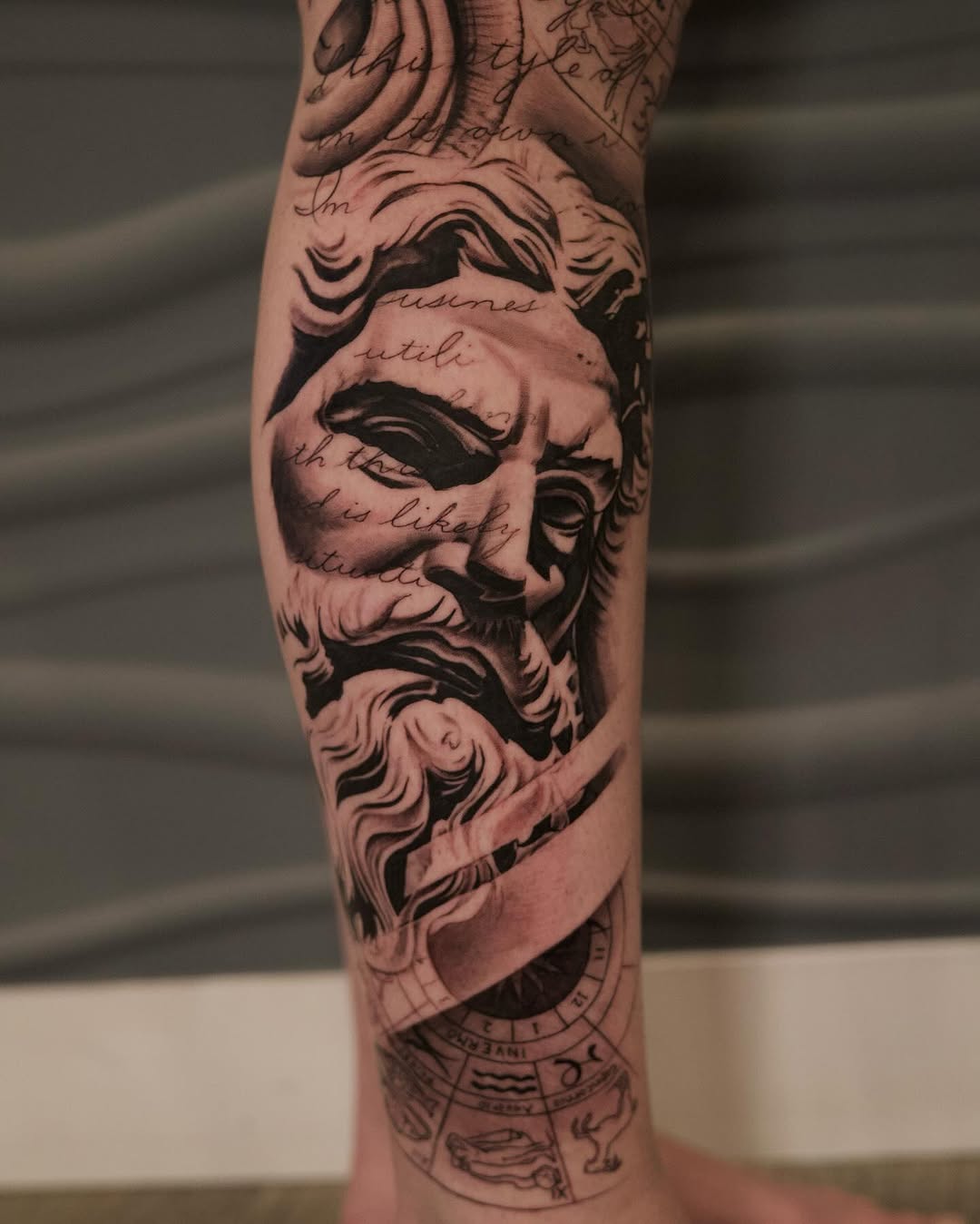 Close-up detail of leg sleeve tattoo with snake design by Adrian Idso in progress