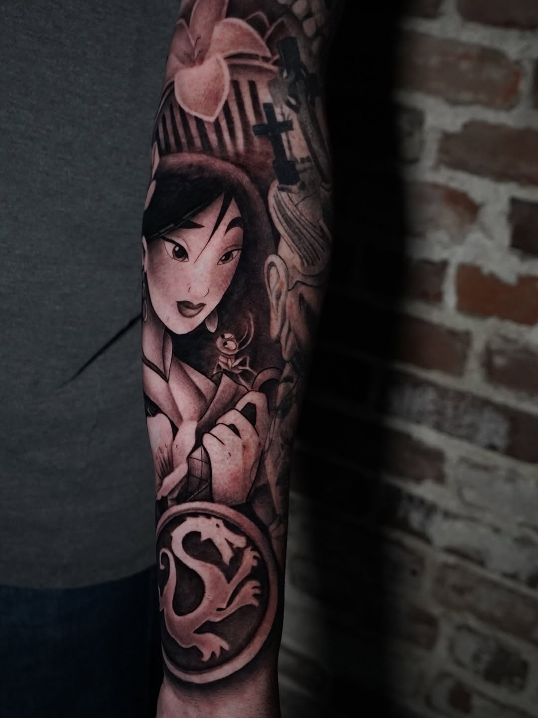 Close-up detail of Mulan character tattoo with intricate flower elements by Charleigh Rae