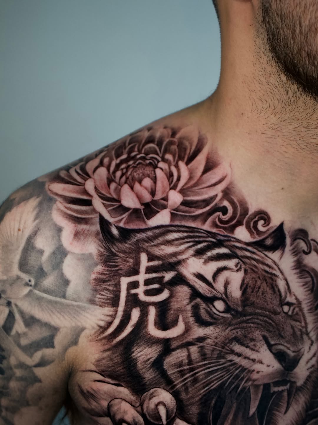 Close up detail of black and grey chest tattoo by Adrian Idso at Broadway Dept