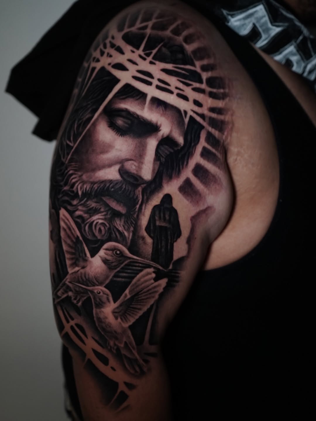 Close-up of custom Jesus piece tattoo showing fine line work at Broadway Dept.
