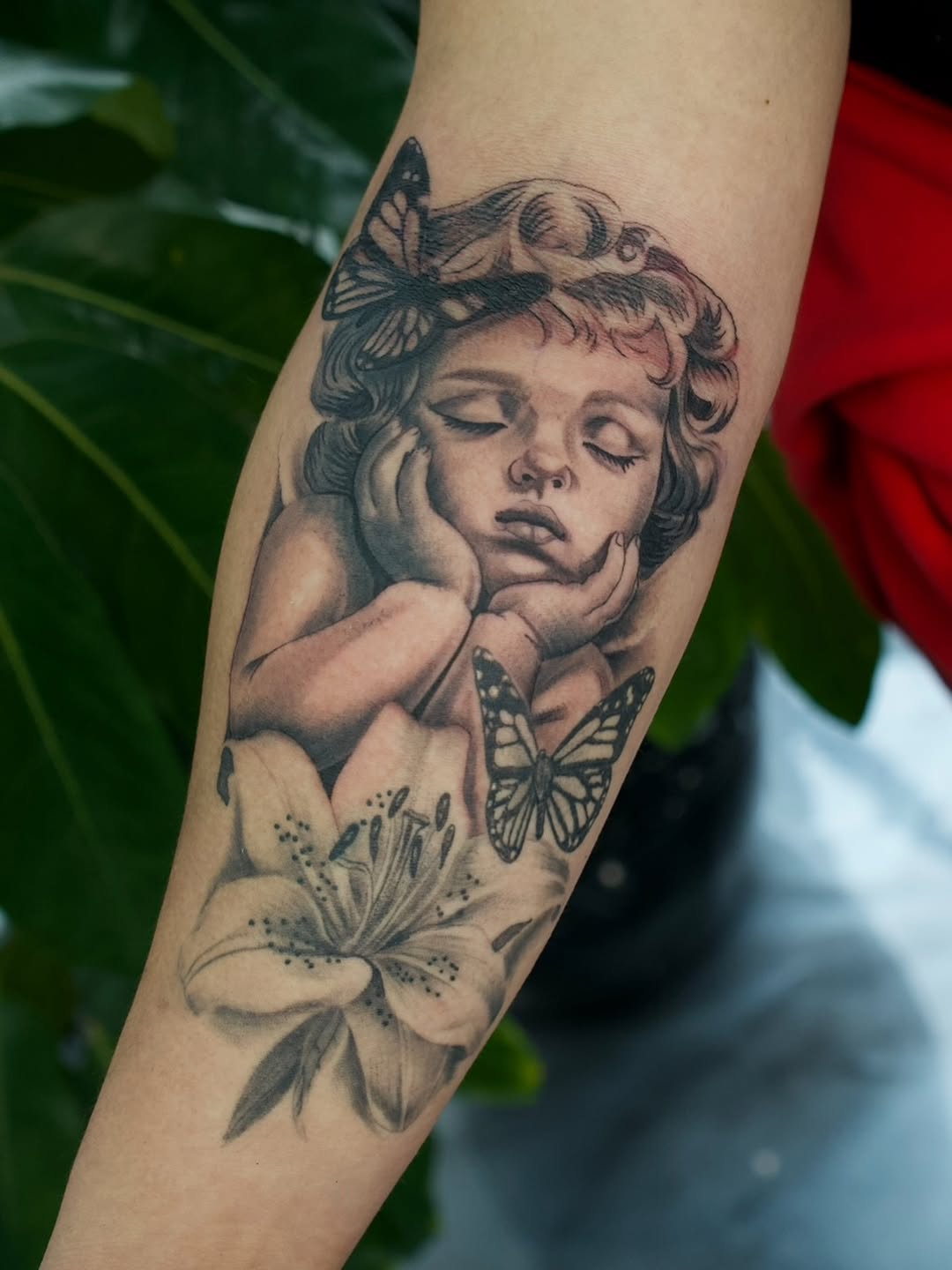 Close-up detail of baby cherub lily tattoo by Jesus Bernal at Broadway Dept. Sacramento