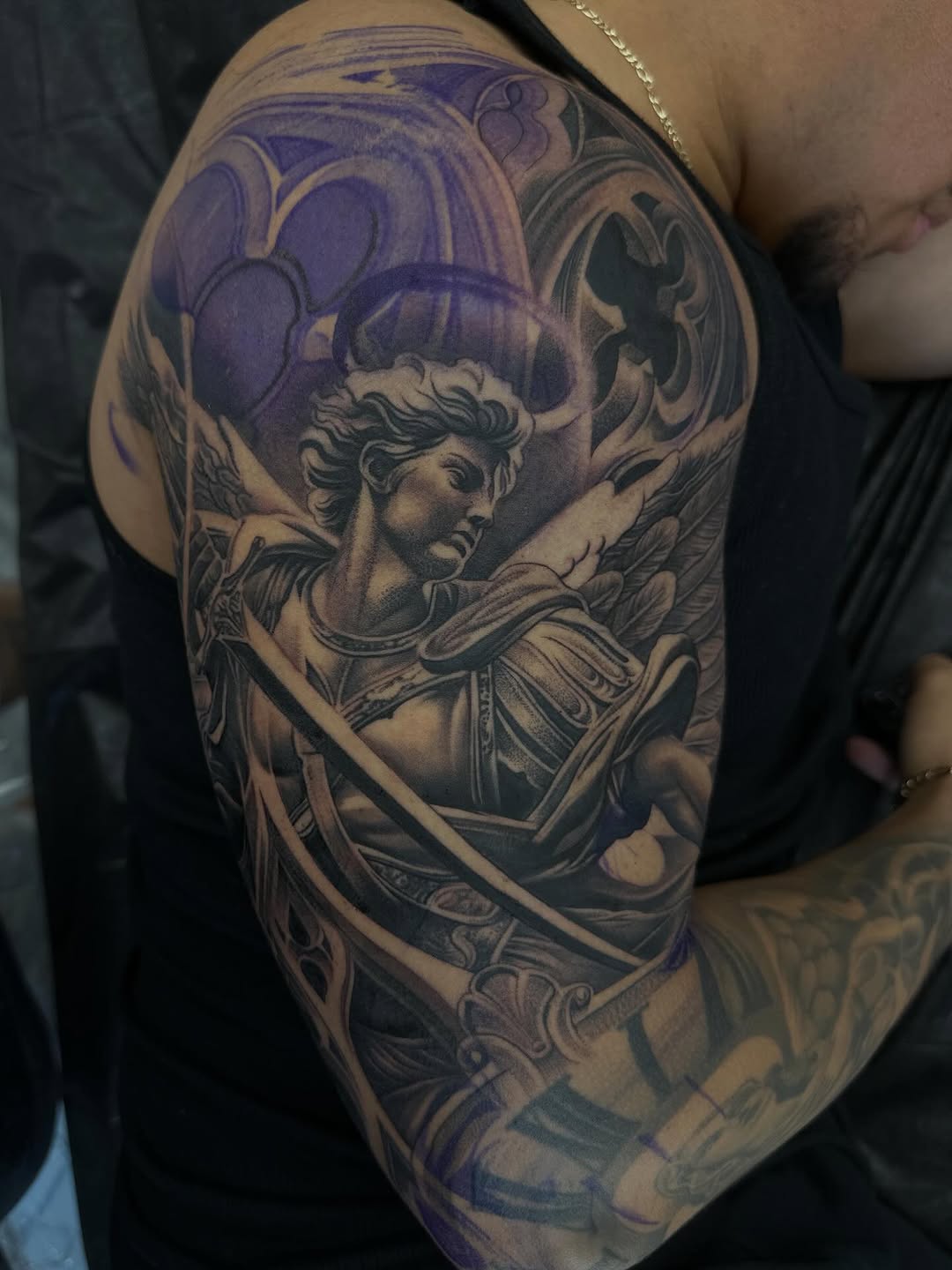 Close-up of archangel sleeve tattoo showing intricate linework and shading by Mauricio Contreras