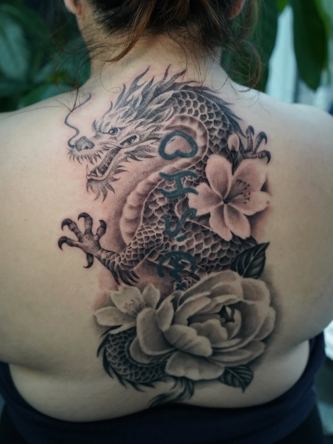 Close-up detail of dragon back piece tattoo with vibrant ink work by Broadway Dept. artist