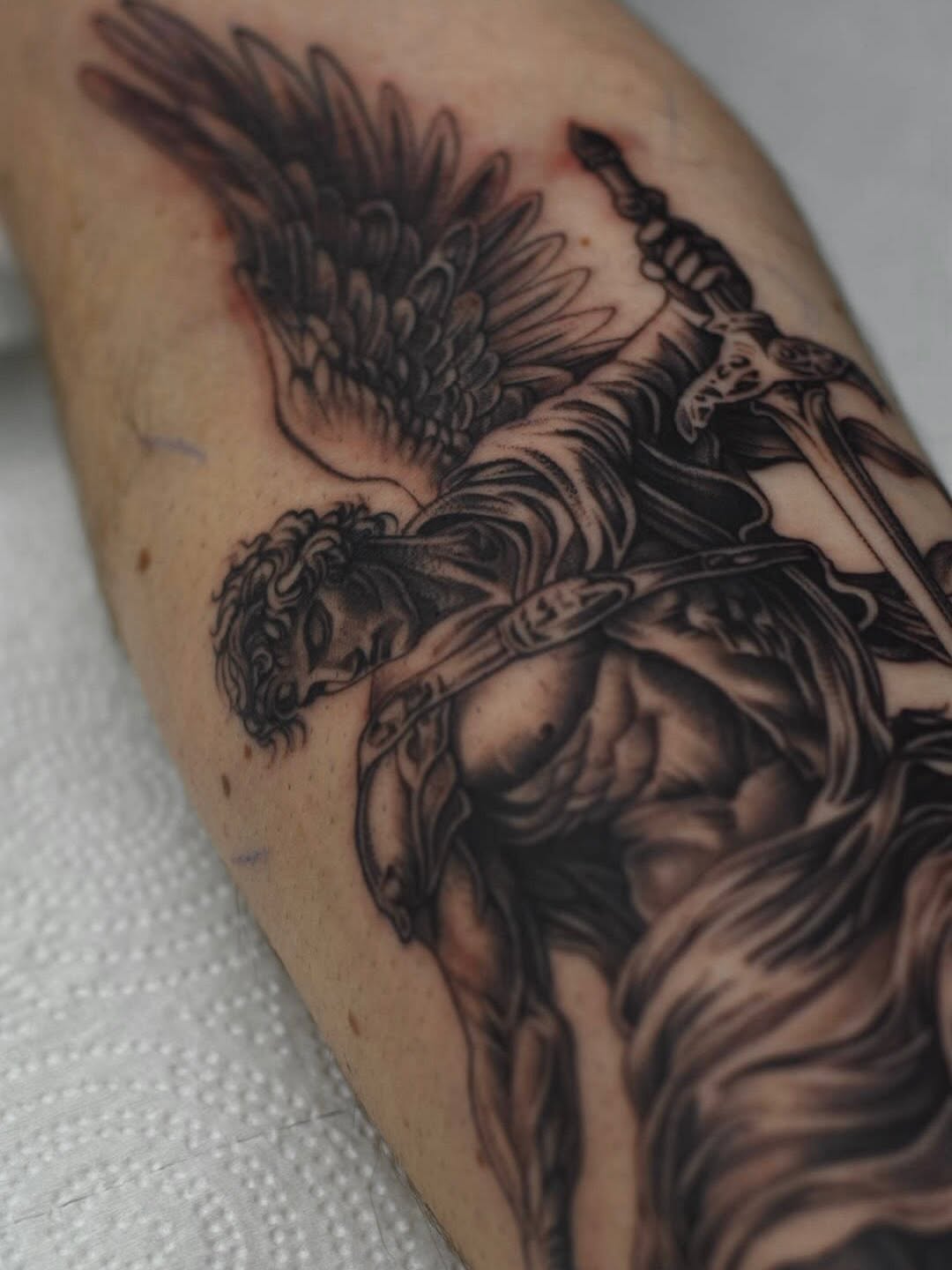 Close-up of Saint Michael archangel tattoo showing intricate linework and shading at Broadway Dept