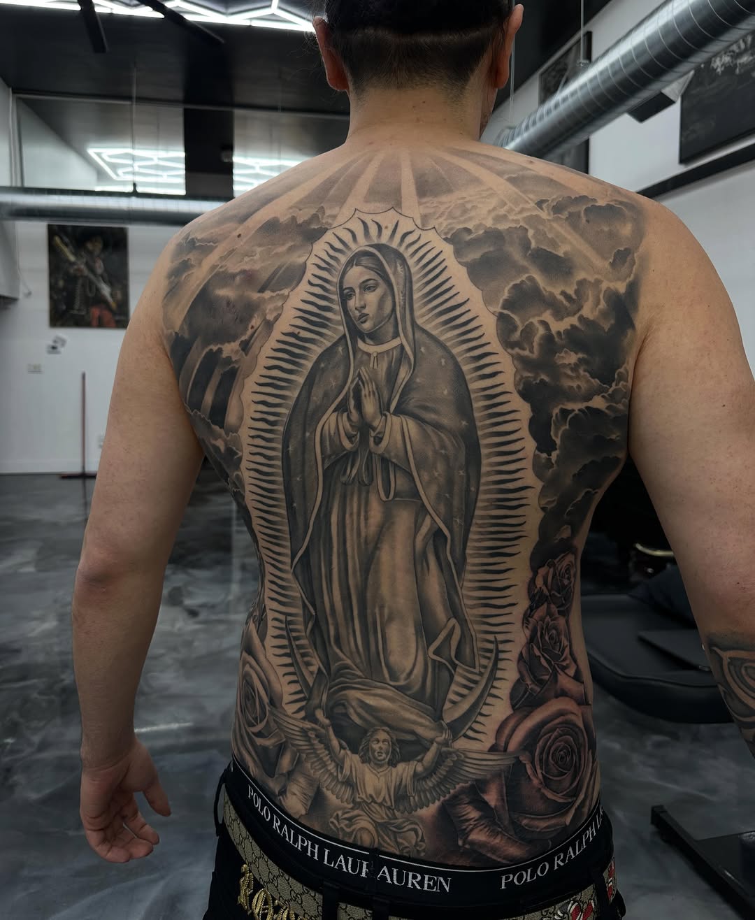 Detailed Virgin Mary religious backpiece tattoo showing line work and shading