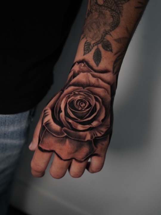 Classic rose tattoo on hand by Broadway Dept. Sacramento