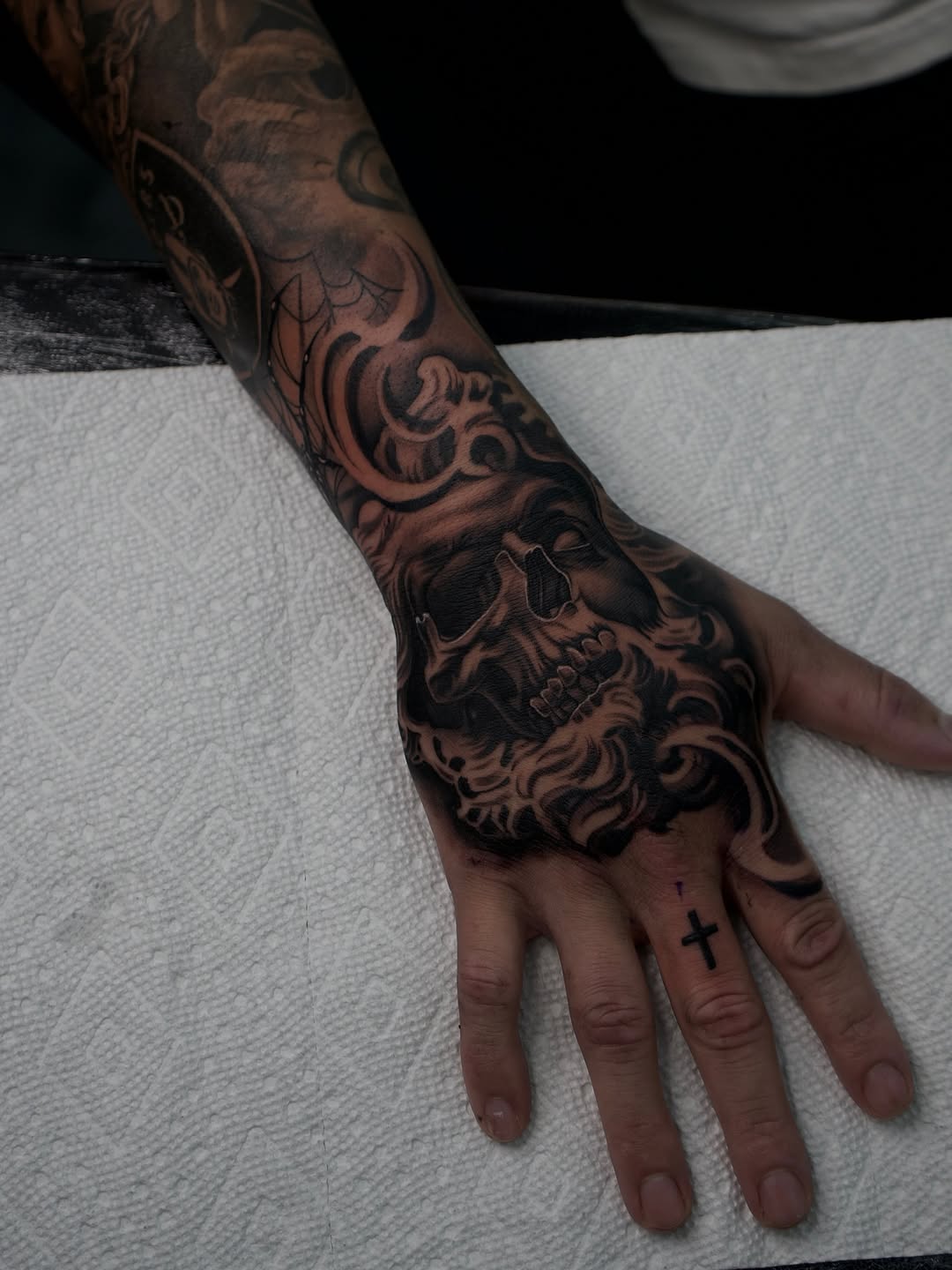 Detailed view of half skull half sculpture hand tattoo by Bella Gomez at Broadway Dept. Sacramento