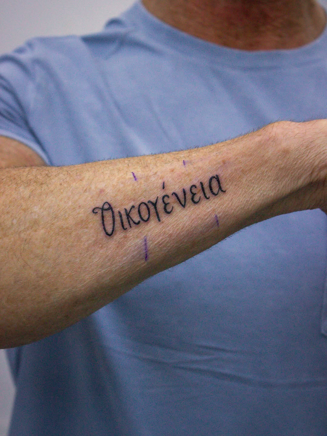 Close-up of black and grey Greek Family script tattoo by Jack Stralen